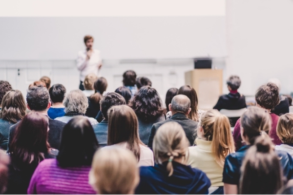 back view of conference attendees and person onstage - Scotia Radio Hytera HP5 series